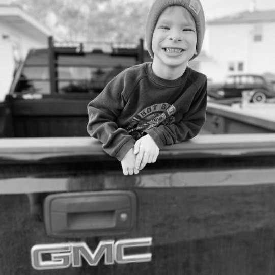 Three year old in back of a truck