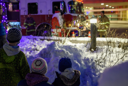 Calum, Lauchlin and mom looking at Santa by a fire truck