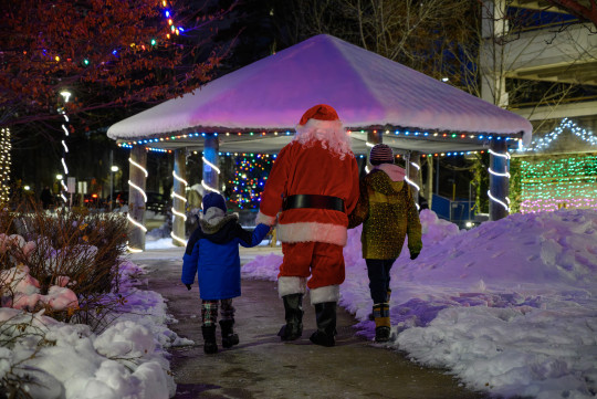 Calum, Santa and Lauchlin holding hands, walking towards the gazebo 