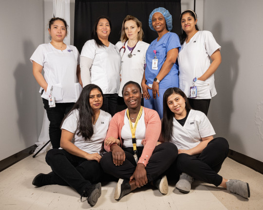 Eight nurses of various ethnicities and medical expertise pose together for a photo
