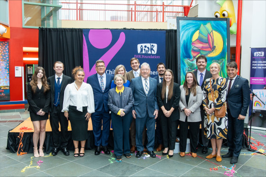 The Garron family stands in front of the stage with the IWK Foundation banner in the back.