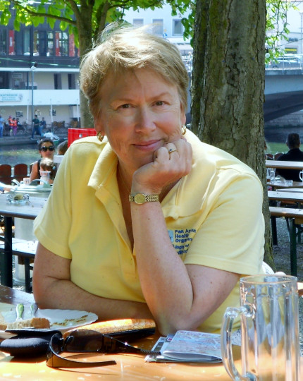 Lynda Cambell sits at a table resting her chin in her hand.