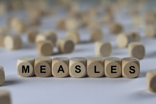 Wooden blocks spell out the words measles.