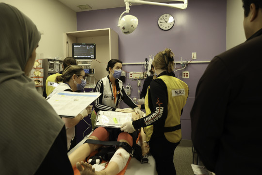 Simulation participants practice on a dummy patient as evaluaters watch