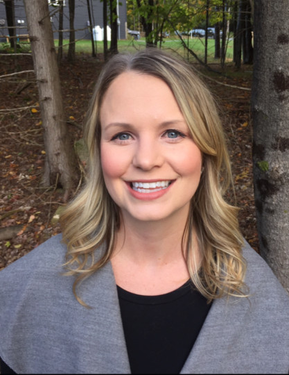 A photo of Lindsey Parker looking at the camera with trees in the background