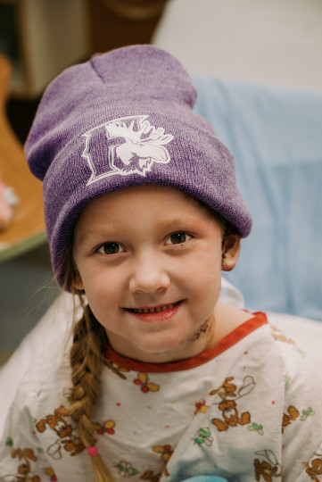 Addy Dodge sits in a hospital bed wearing a purple Mooseheads toque.