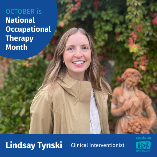 Lindsay Tynski stands in a garden by a statue.