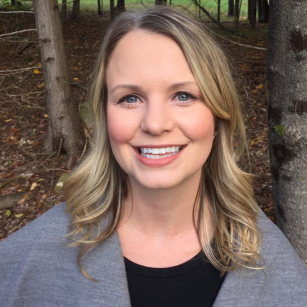 A photo of Lindsey Parker looking at the camera with trees in the background