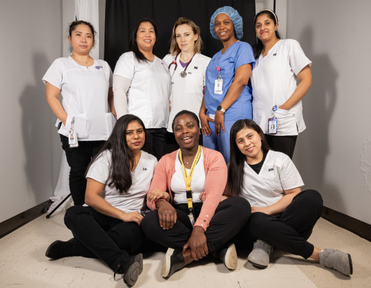 Eight nurses of various ethnicities and medical expertise pose together for a photo