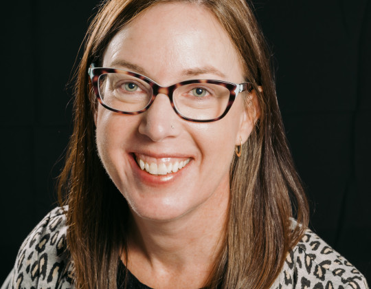 Smiling brunette woman in glasses.