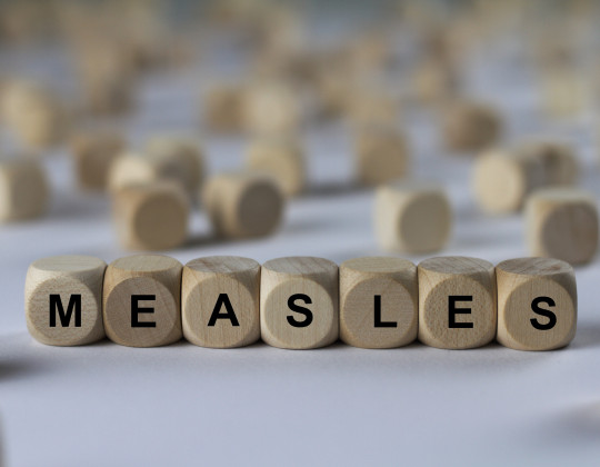 Wooden blocks spell out the words measles.