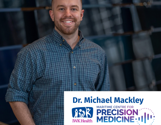 Dr. Michael Mackley stands in front of a dark background.