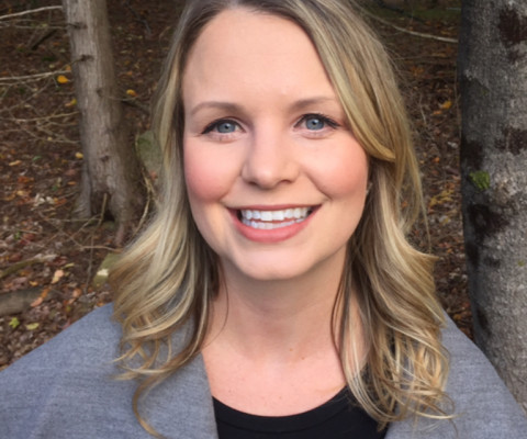 A photo of Lindsey Parker looking at the camera with trees in the background